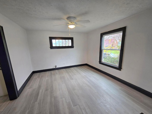 spare room featuring ceiling fan, a textured ceiling, and light wood-type flooring