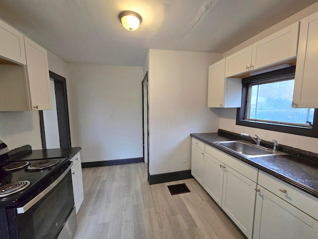 kitchen featuring white cabinets, light hardwood / wood-style flooring, sink, and black / electric stove