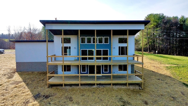 rear view of house with a wooden deck and a yard