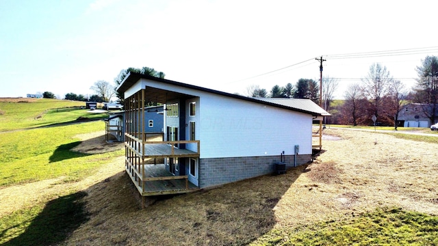 view of side of property with a lawn and cooling unit