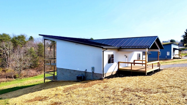 view of side of home with a yard, cooling unit, and a deck