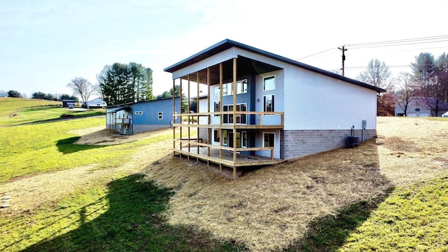 rear view of property with central AC and a yard