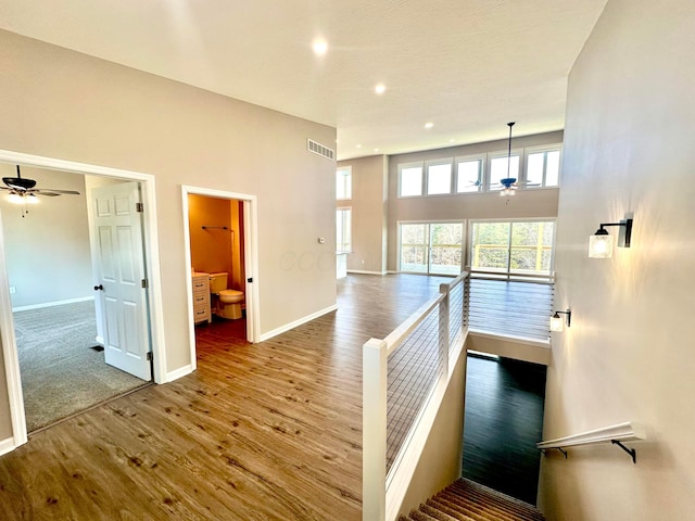 staircase with wood-type flooring and ceiling fan