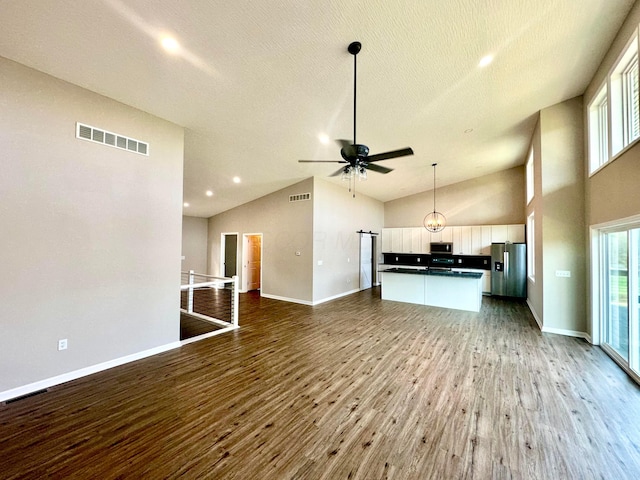 unfurnished living room featuring hardwood / wood-style flooring, ceiling fan, a textured ceiling, and high vaulted ceiling