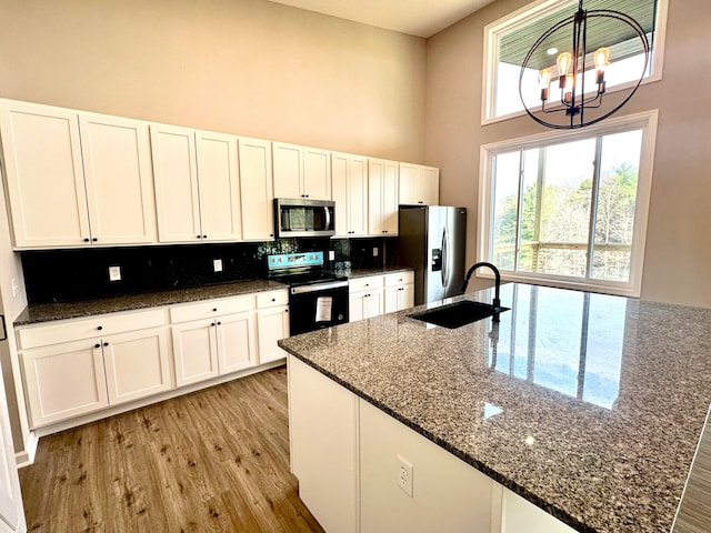 kitchen with sink, white cabinets, a chandelier, and appliances with stainless steel finishes