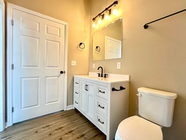 bathroom featuring vanity, toilet, and wood-type flooring