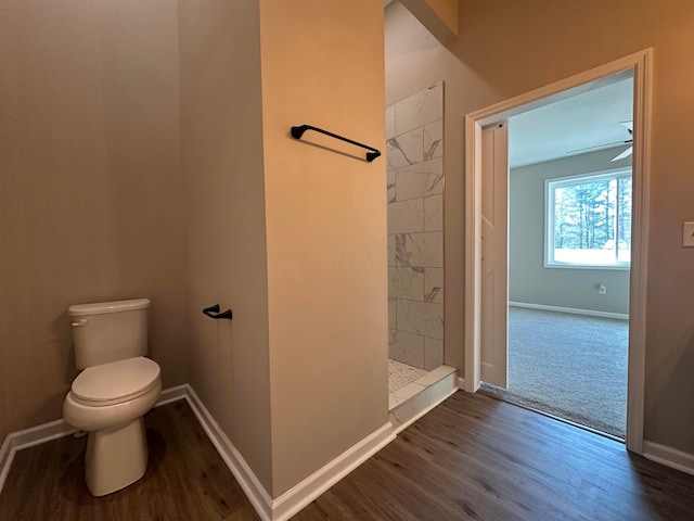 bathroom with a shower, toilet, and hardwood / wood-style flooring