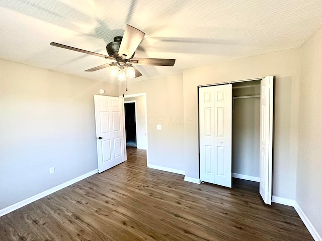 unfurnished bedroom with ceiling fan, dark hardwood / wood-style floors, and a closet