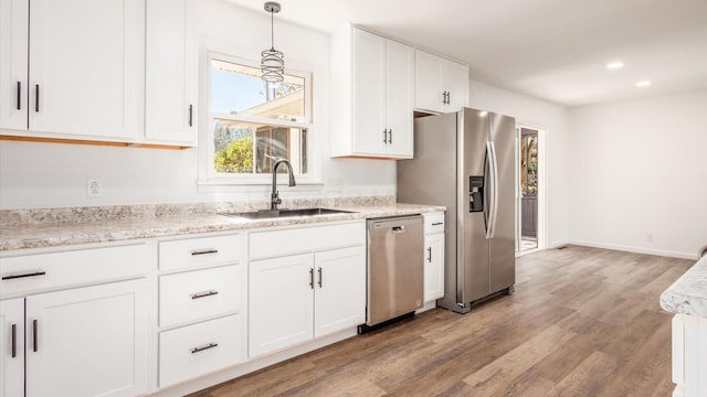 kitchen with white cabinetry, sink, light hardwood / wood-style flooring, and appliances with stainless steel finishes