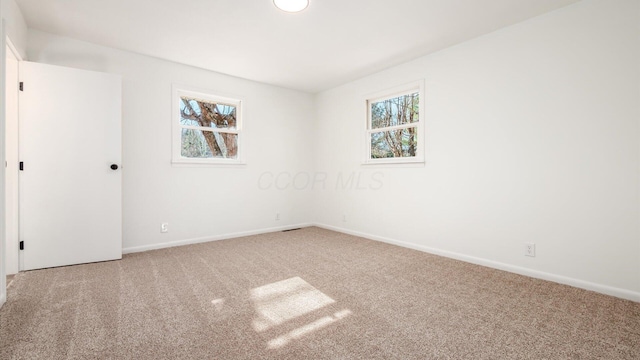 empty room with a wealth of natural light and carpet