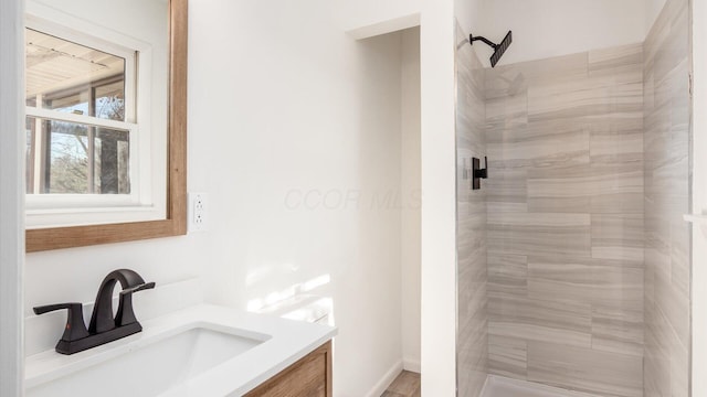 bathroom featuring a tile shower and vanity