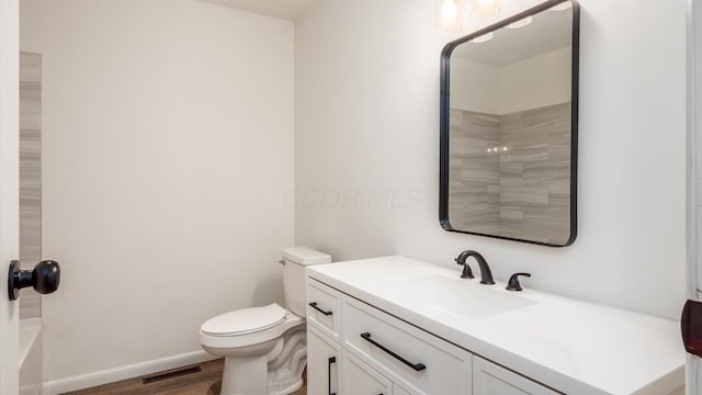 bathroom with toilet, vanity, and hardwood / wood-style flooring