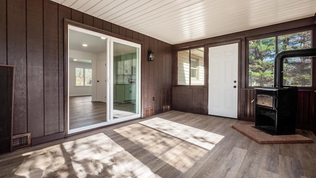 unfurnished sunroom featuring a wood stove