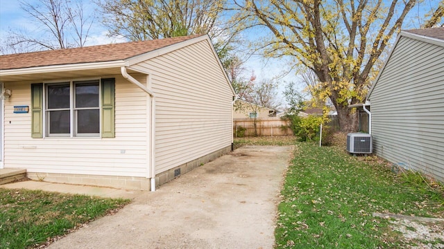 view of home's exterior featuring central air condition unit and a yard