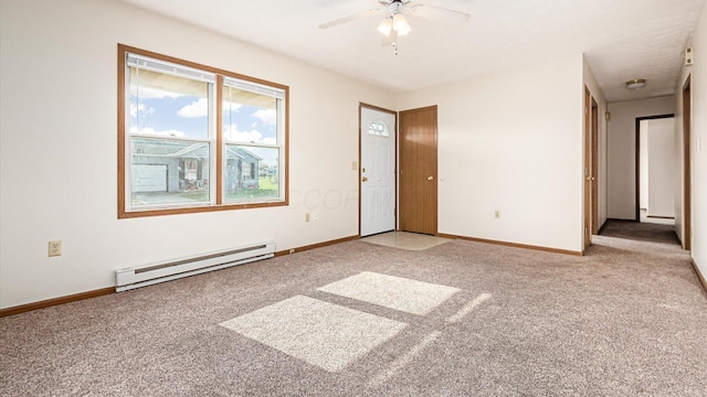 carpeted spare room with ceiling fan and a baseboard heating unit