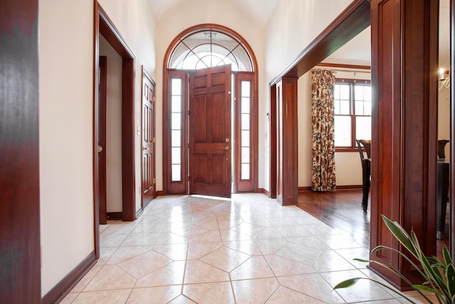 tiled foyer featuring vaulted ceiling