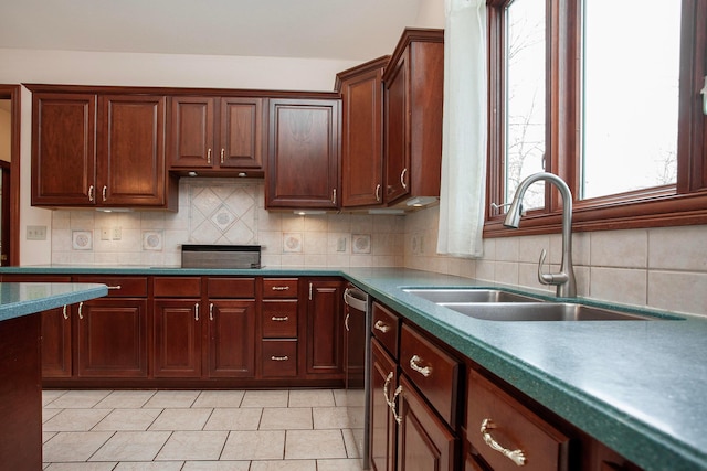 kitchen with backsplash, dishwasher, sink, and black stovetop