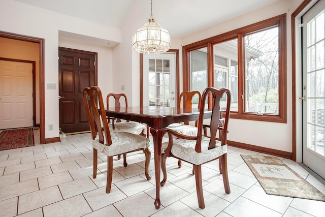 dining room featuring a notable chandelier, a healthy amount of sunlight, light tile patterned floors, and lofted ceiling