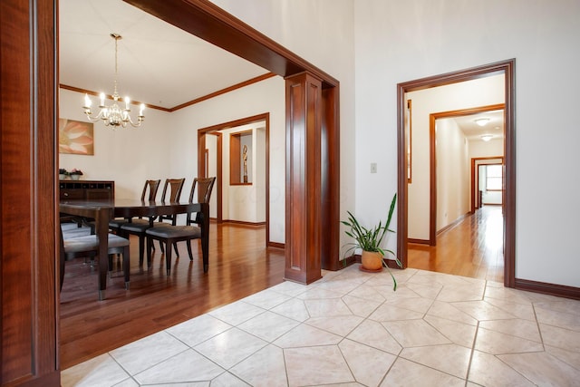 interior space with a notable chandelier, ornamental molding, and light hardwood / wood-style flooring