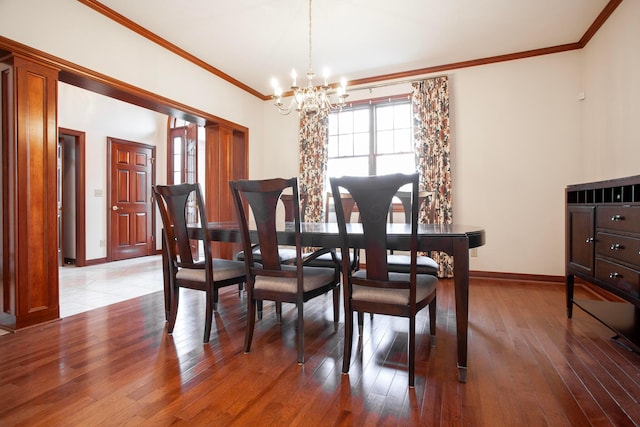 dining room featuring crown molding, hardwood / wood-style floors, and a notable chandelier