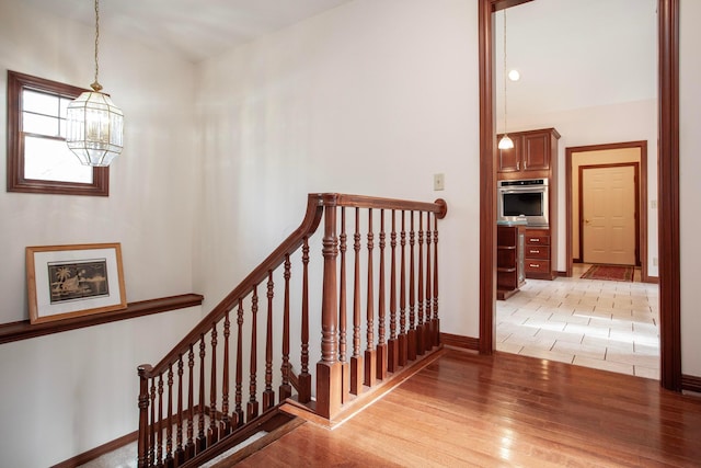 stairs with a chandelier and wood-type flooring