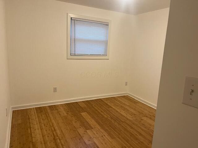 empty room with dark hardwood / wood-style flooring