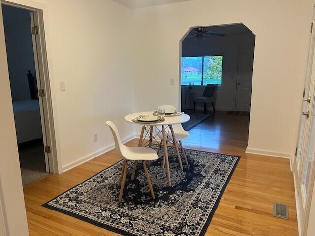 dining room with ceiling fan and hardwood / wood-style flooring