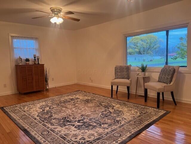 sitting room featuring wood-type flooring and ceiling fan