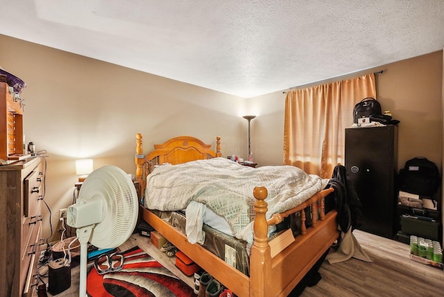 bedroom with wood-type flooring and a textured ceiling