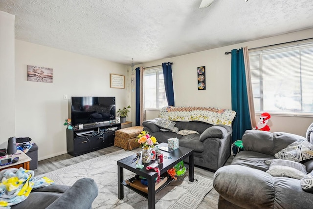 living room with a textured ceiling and light wood-type flooring