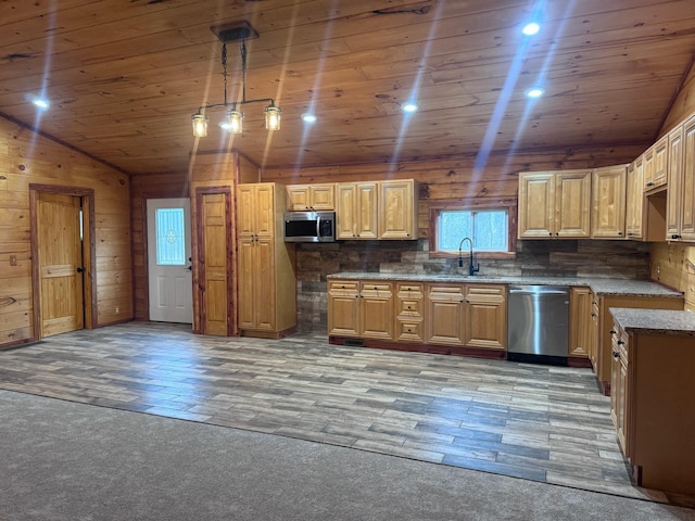 kitchen with lofted ceiling, wooden walls, light hardwood / wood-style flooring, decorative light fixtures, and stainless steel appliances