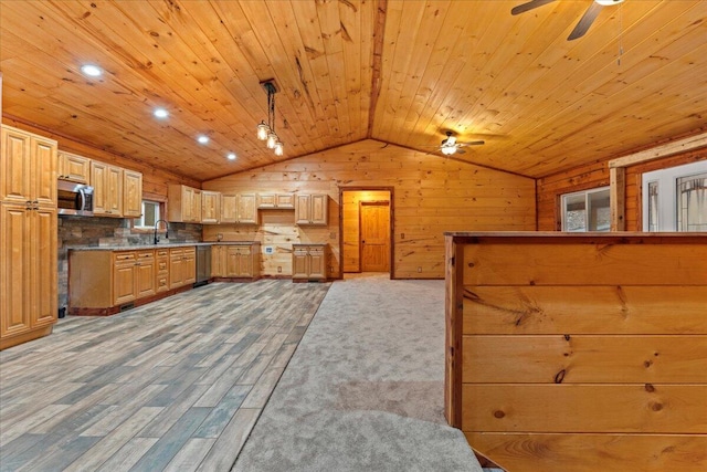 kitchen with pendant lighting, wood walls, lofted ceiling, hardwood / wood-style flooring, and stainless steel appliances