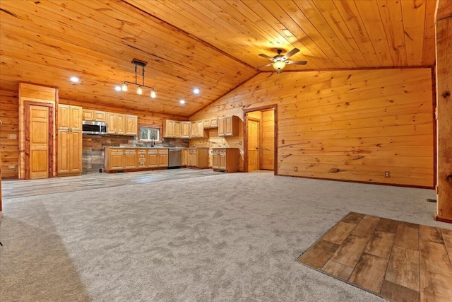 unfurnished living room featuring wood walls, light colored carpet, wooden ceiling, and ceiling fan