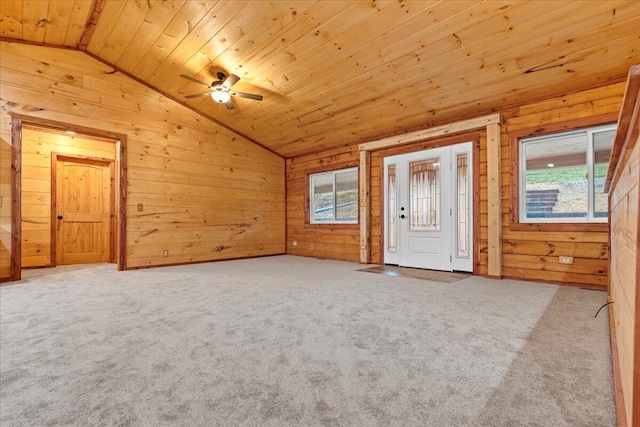 interior space featuring carpet, wood walls, wood ceiling, and multiple windows