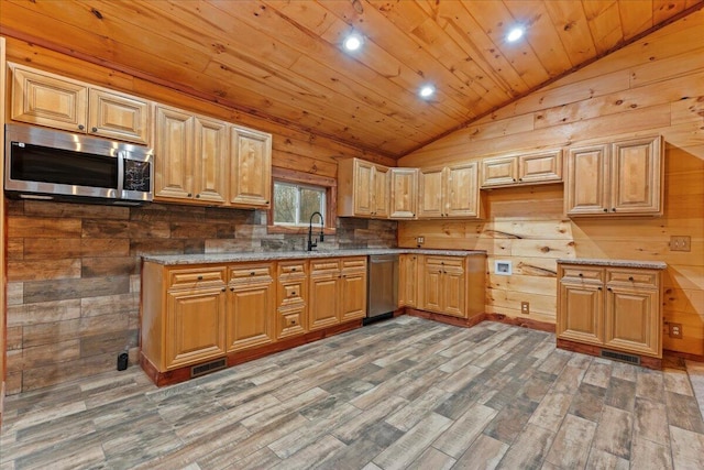 kitchen with appliances with stainless steel finishes, dark hardwood / wood-style flooring, vaulted ceiling, wooden walls, and wooden ceiling