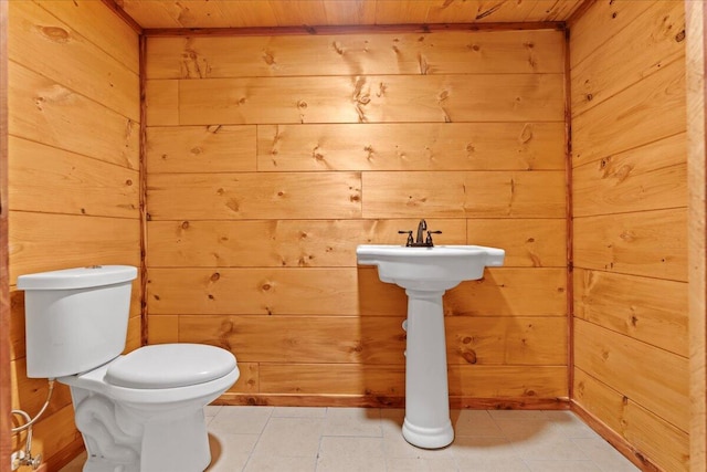 bathroom featuring toilet, wooden ceiling, and wood walls