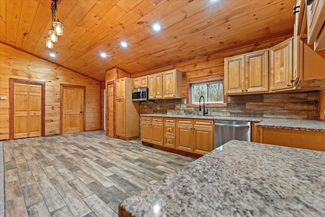 kitchen featuring stainless steel appliances, decorative light fixtures, hardwood / wood-style floors, lofted ceiling, and wood walls