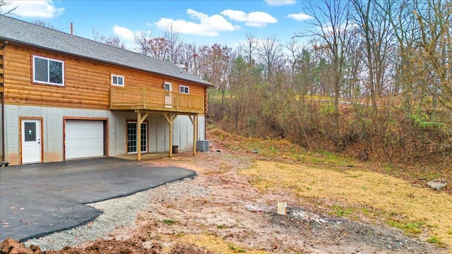 view of home's exterior with central AC, a garage, and a deck