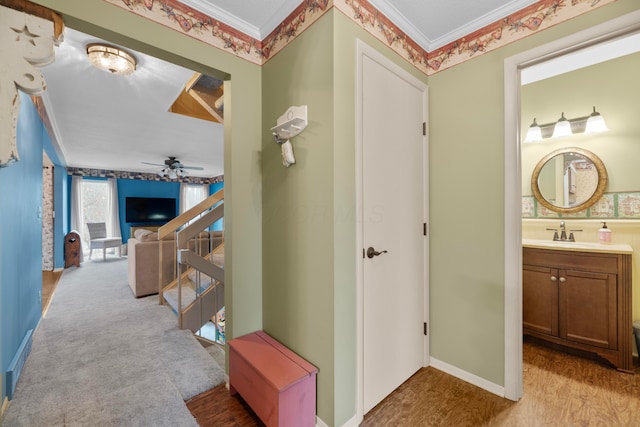 hall featuring light hardwood / wood-style floors, ornamental molding, and sink