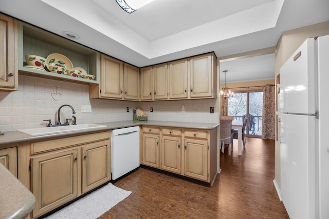 kitchen with sink, an inviting chandelier, dark hardwood / wood-style flooring, pendant lighting, and white appliances