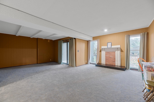 interior space with a healthy amount of sunlight, light colored carpet, and beam ceiling