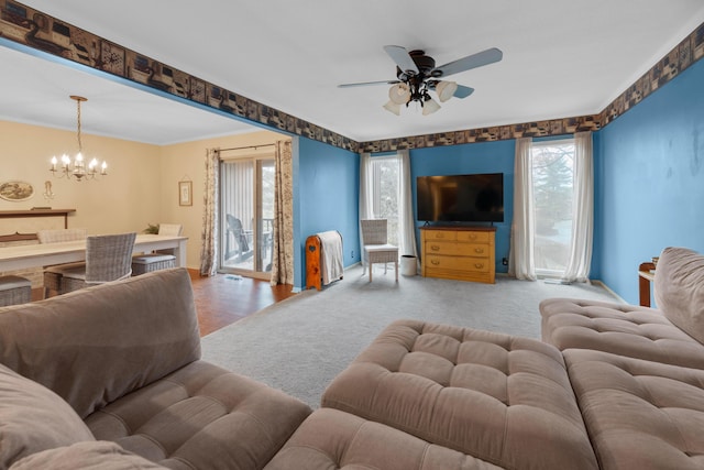 living room featuring ceiling fan with notable chandelier and crown molding