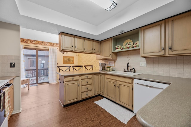 kitchen featuring backsplash, white appliances, a raised ceiling, dark wood-type flooring, and sink