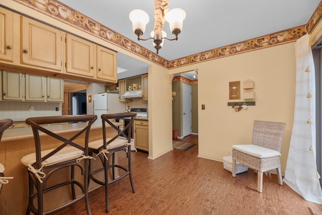 kitchen featuring decorative backsplash, white refrigerator, an inviting chandelier, light hardwood / wood-style floors, and hanging light fixtures