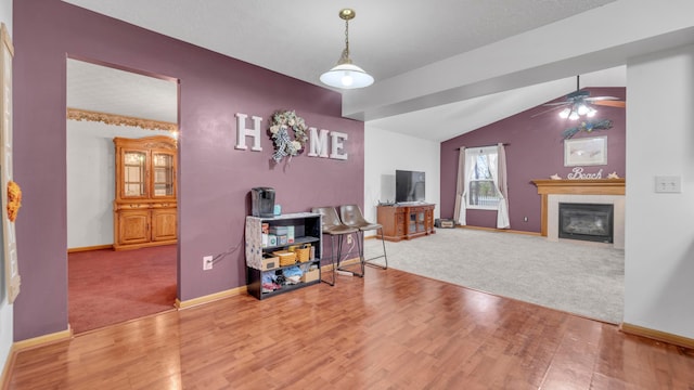 living room featuring ceiling fan, hardwood / wood-style floors, and lofted ceiling