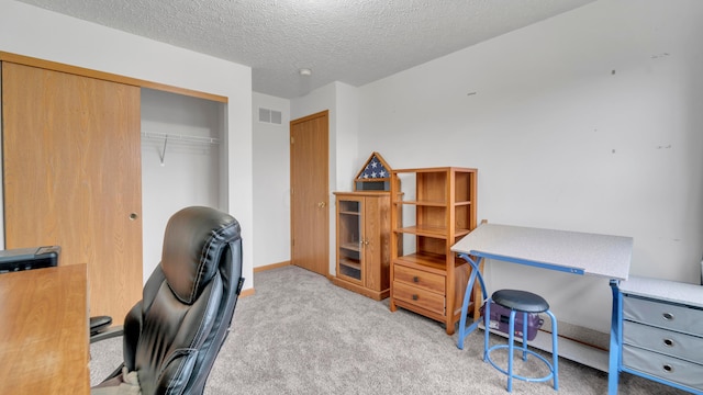 home office with a textured ceiling and light carpet