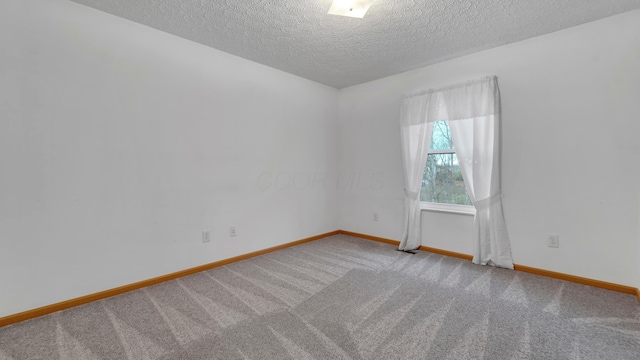 carpeted empty room featuring a textured ceiling