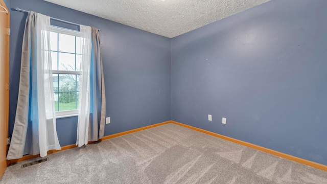 carpeted spare room featuring a textured ceiling