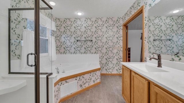 bathroom with vanity, plus walk in shower, and a textured ceiling