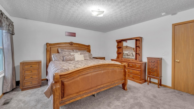 bedroom featuring light colored carpet and a textured ceiling